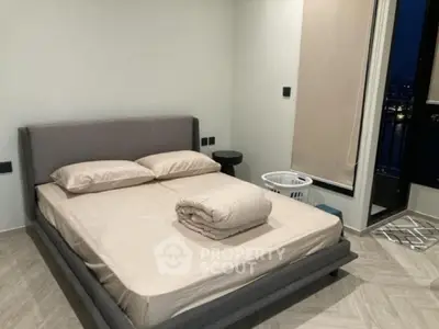 Modern bedroom with stylish bed and nightstand, featuring a cozy ambiance and contemporary design.