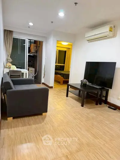 Modern living room with sleek furniture and large TV, perfect for relaxation and entertainment.
