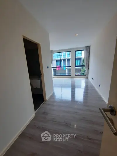 Spacious modern apartment with large windows and sleek flooring, offering abundant natural light and a contemporary feel.