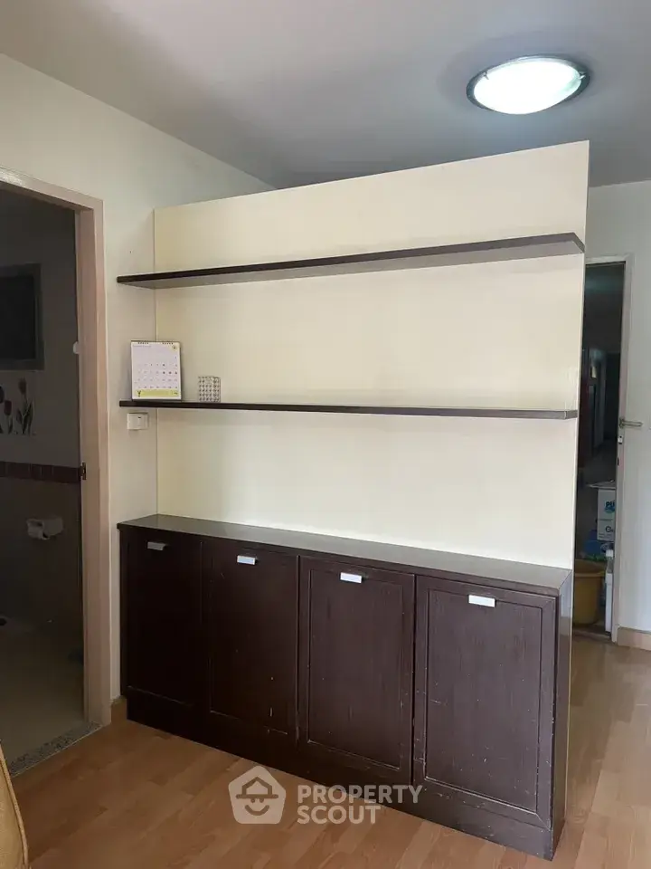 Spacious interior with wooden flooring and built-in storage shelves, ideal for modern living.