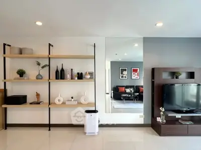 Modern living room with stylish shelving and TV unit, spacious and well-lit.