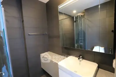 Modern bathroom with sleek design and large mirror in contemporary apartment.