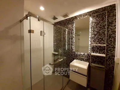 Modern bathroom with glass shower and mosaic tile wall