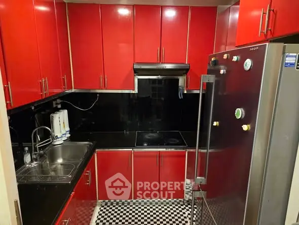 Modern red kitchen with sleek cabinets and stainless steel appliances