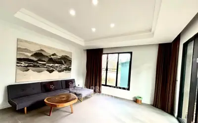 Spacious living room with modern decor and large window for natural light.