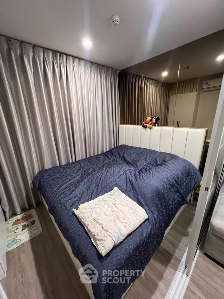Cozy bedroom with elegant curtains and plush bedding in modern apartment