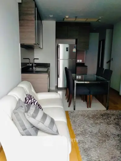 Modern open-layout kitchen and living area with stylish decor and stainless steel appliances.