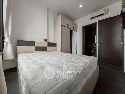 Modern bedroom with stylish decor and ample natural light, featuring a comfortable bed and sleek storage solutions.