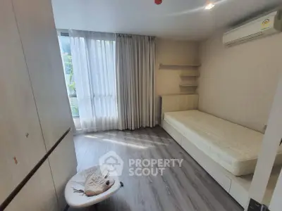 Cozy bedroom with natural light, minimalist design, and air conditioning in modern apartment.
