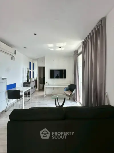 Modern living room with sleek furniture and large windows for natural light.