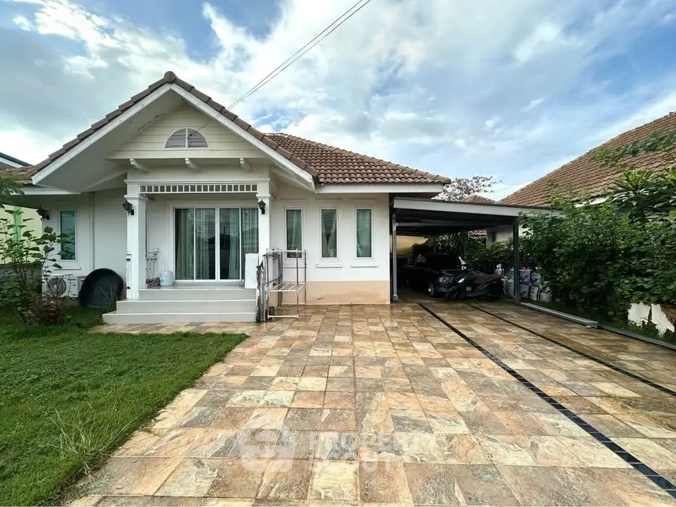 Charming single-story home with spacious driveway and lush greenery