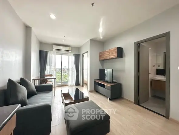 Modern living room with sleek furniture and balcony view in a stylish apartment.
