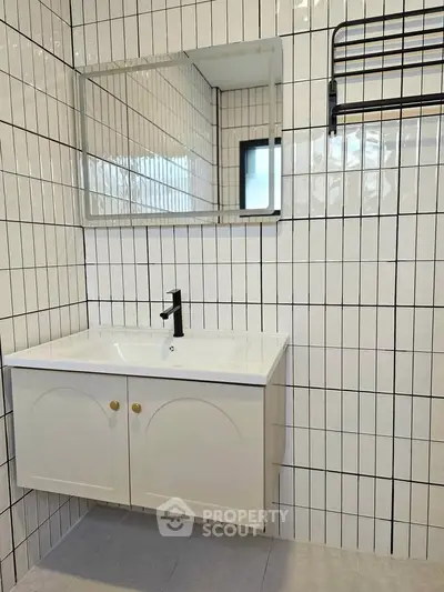 Modern bathroom with sleek white tiles and stylish vanity unit