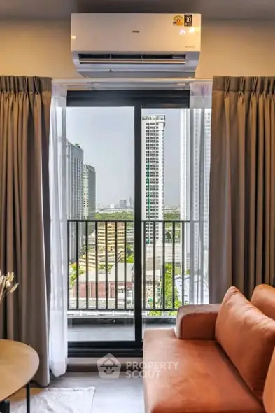 Modern living room with city view from balcony, featuring stylish sofa and air conditioning unit.