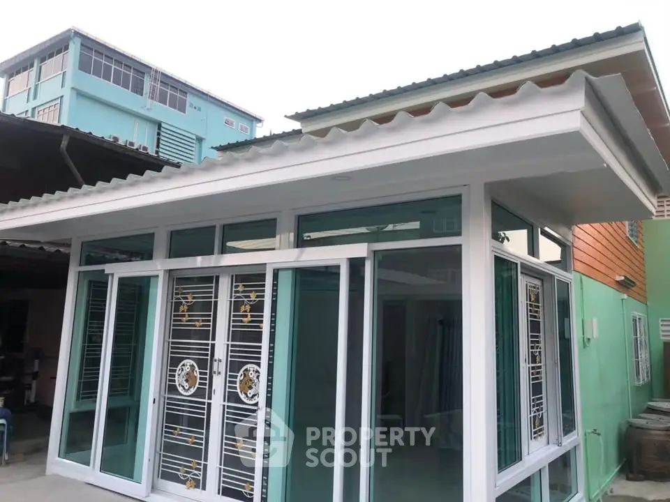 Modern single-story house with large glass doors and unique roof design, ideal for contemporary living.