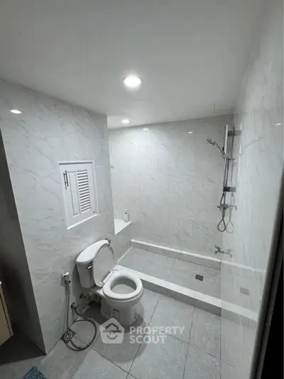 Modern bathroom with sleek marble tiles and walk-in shower