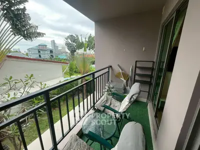 Charming balcony with cozy seating and lush garden view, perfect for relaxation.