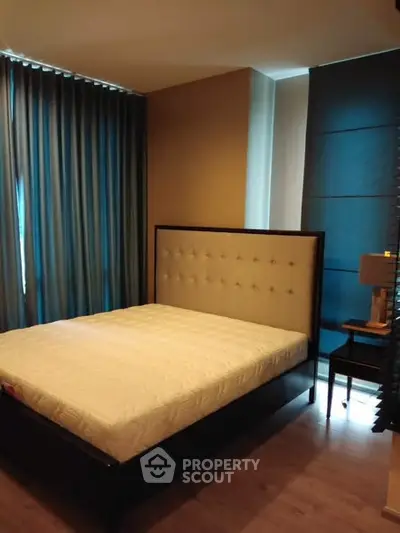 Cozy bedroom with elegant bed and floor-to-ceiling curtains in modern apartment.