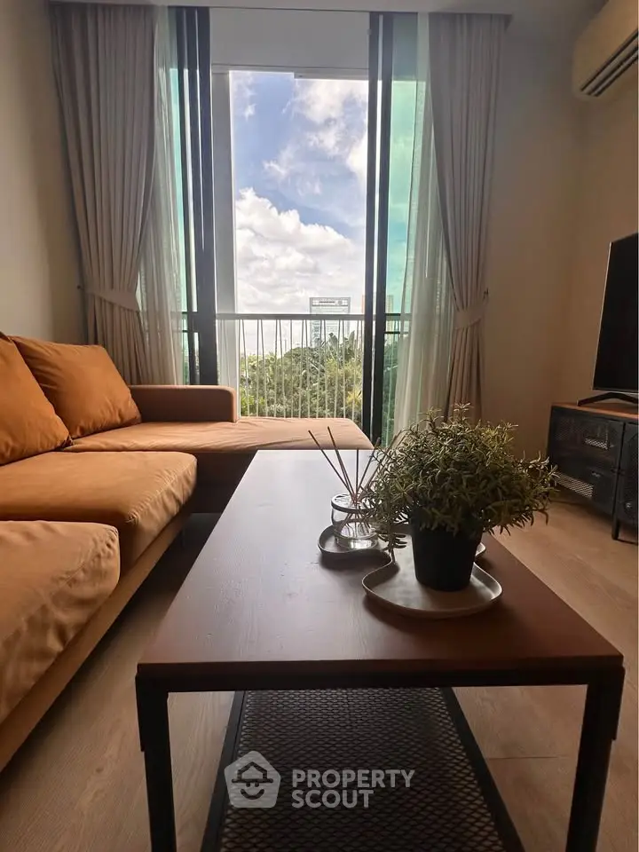 Modern living room with large windows and scenic view, featuring a cozy sofa and stylish coffee table.