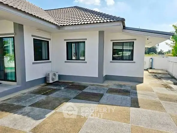 Charming single-story home with tiled patio and modern exterior design.