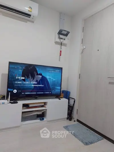 Modern living room with TV, air conditioning, and stylish storage unit.