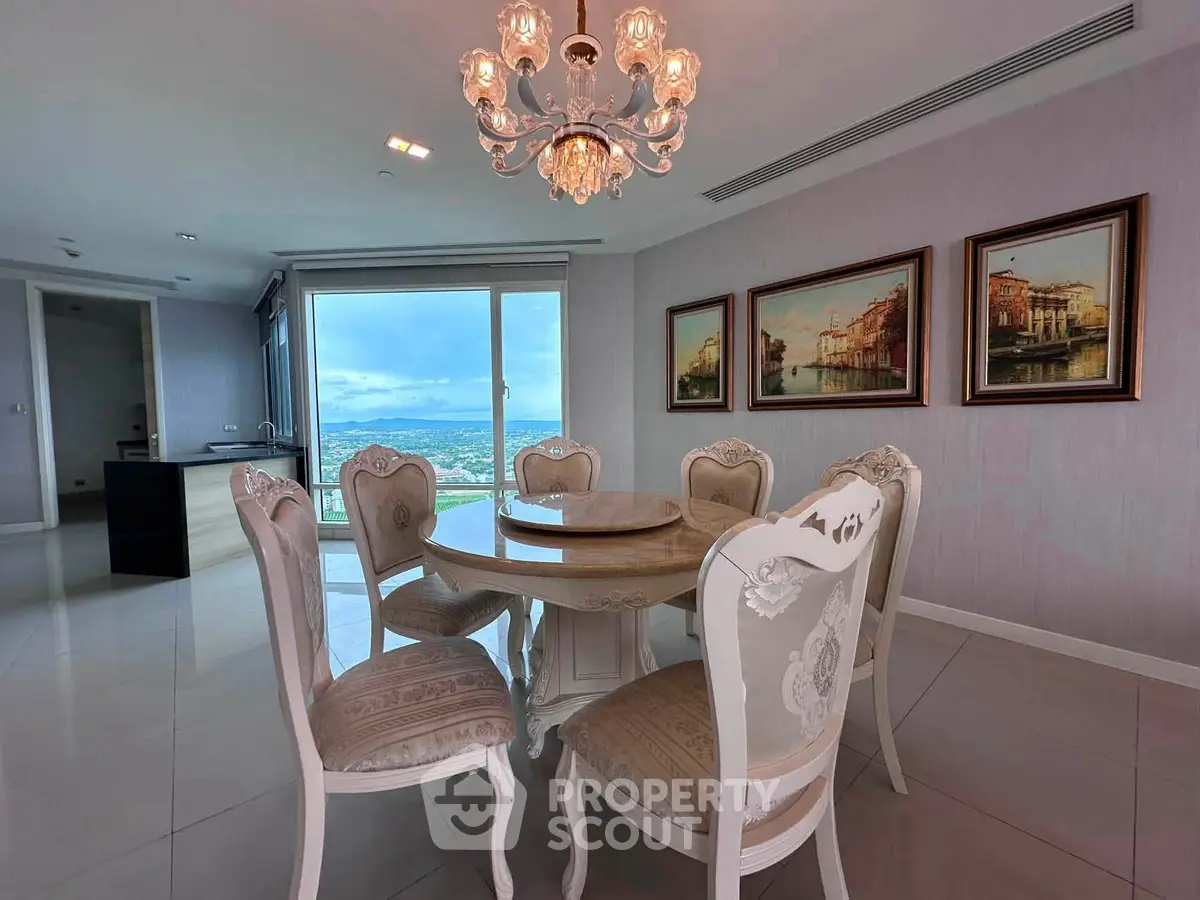 Elegant dining area with chandelier and stunning view in luxury apartment