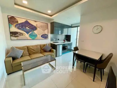 Modern living room with stylish decor and compact kitchen in open layout apartment.