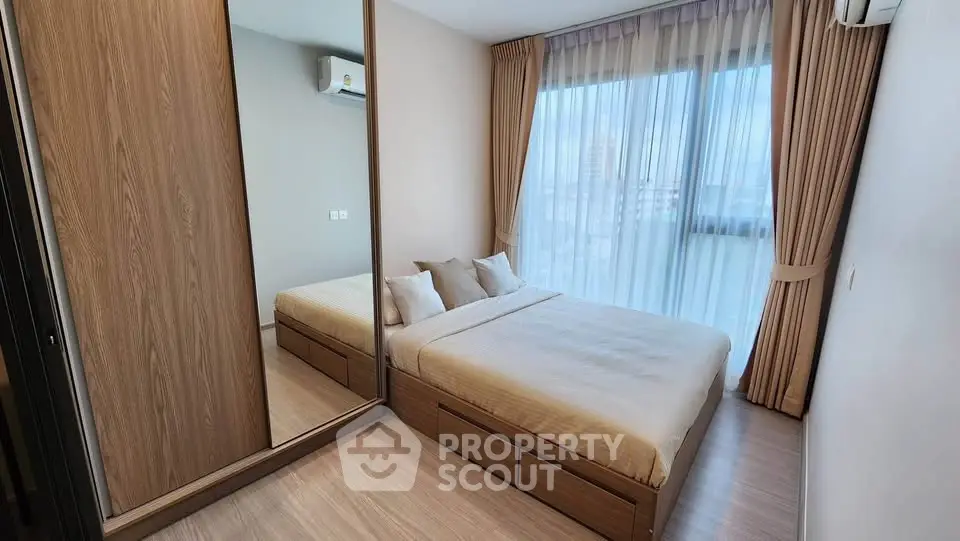 Modern bedroom with large window and wooden wardrobe in a stylish apartment.