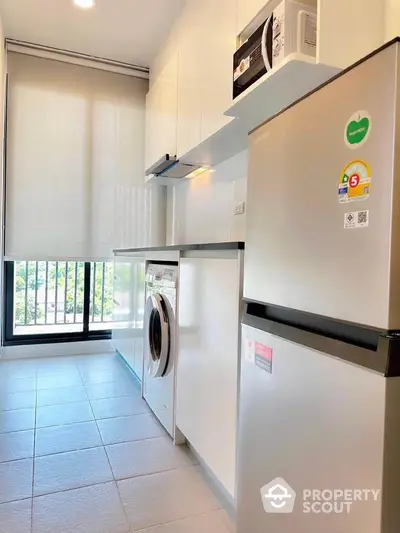 Modern kitchen with sleek appliances and large window view