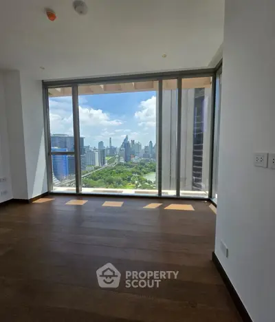 Stunning city view from a modern high-rise apartment with floor-to-ceiling windows.