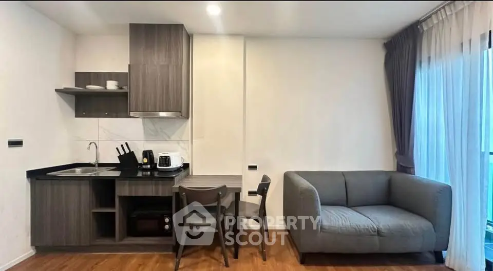 Modern open-layout kitchen and cozy living room with stylish furniture and natural light.