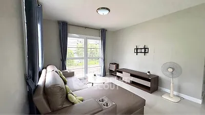 Cozy living room with modern sofa and large window offering natural light.