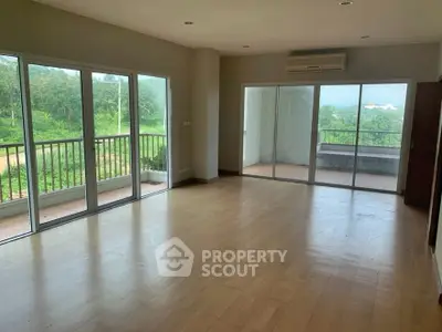 Spacious living room with large windows and scenic balcony view