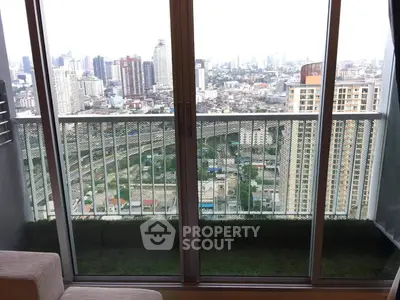 Stunning city view from a modern apartment balcony with glass doors.