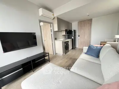 Modern living room with sleek furniture and integrated kitchen appliances, perfect for urban living.