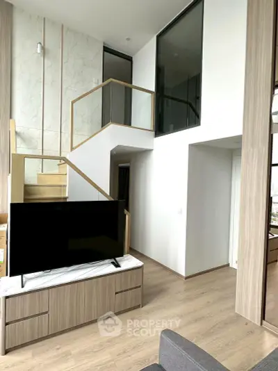 Modern duplex living room with stylish staircase and large TV