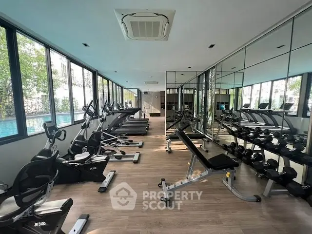 Modern gym with state-of-the-art equipment and mirrored walls in a luxury residential building.