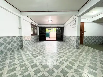 Spacious tiled interior with open layout and ample natural light, perfect for versatile use.
