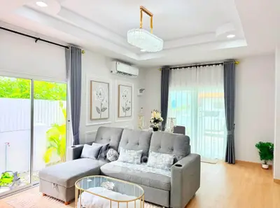 Elegant living room with modern decor, large windows, and stylish furniture, perfect for relaxation and entertaining.
