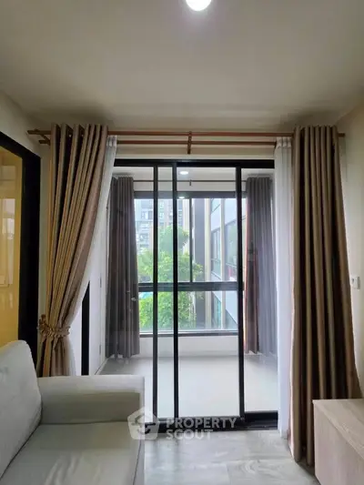 Modern living room with large windows and balcony view in a stylish apartment.