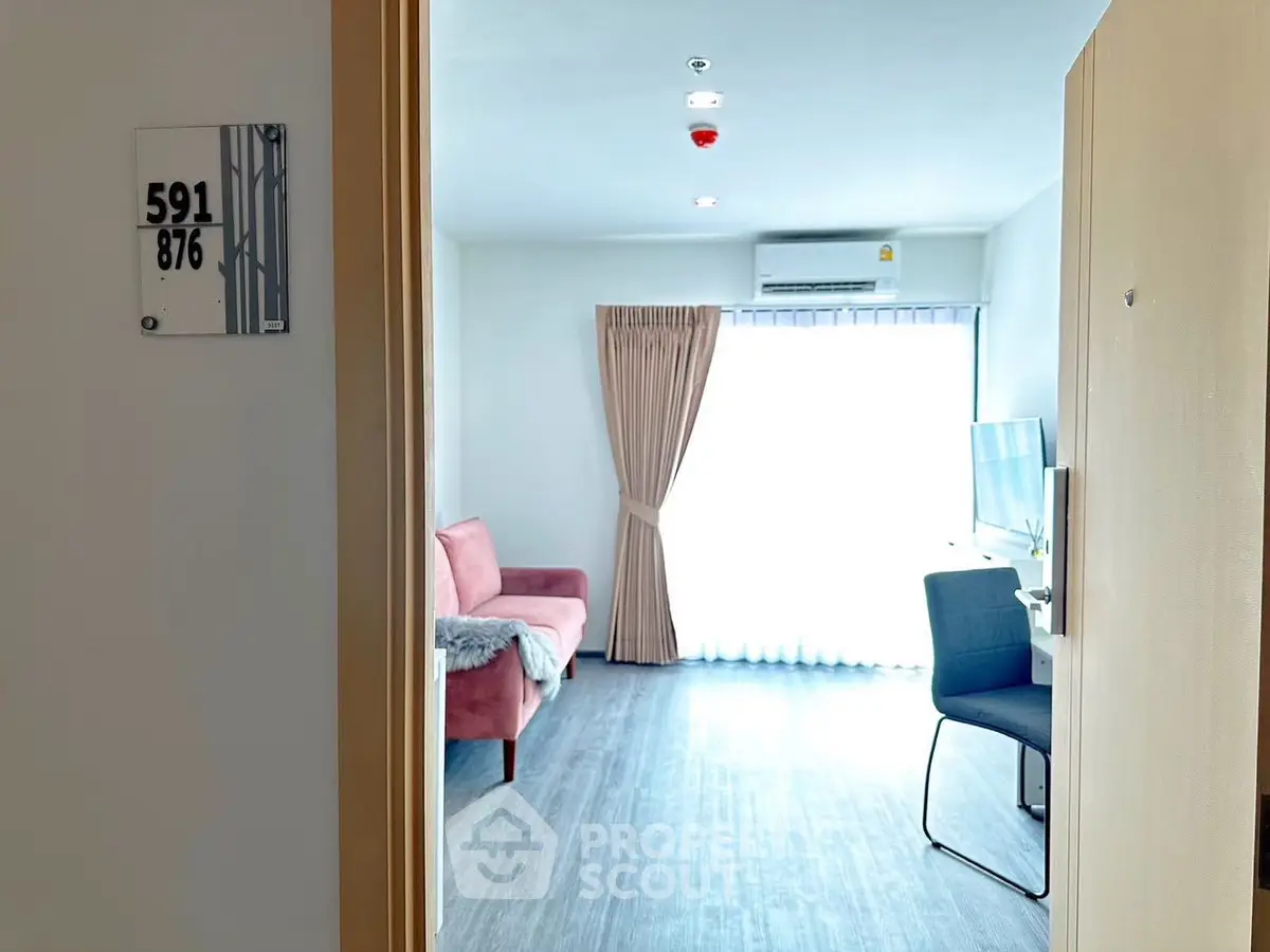 Bright modern living room with pink sofa and large window