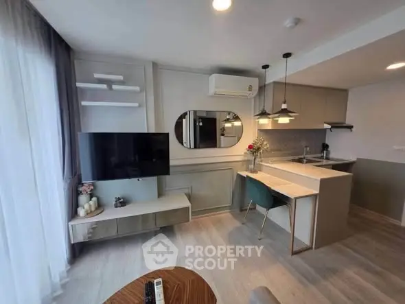 Modern living room with open kitchen, stylish decor, and natural light.