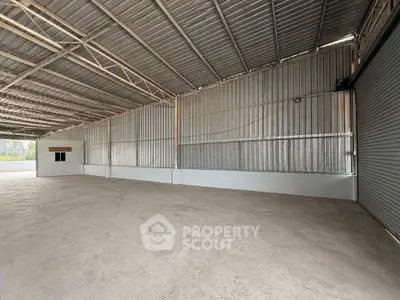 Spacious industrial warehouse with high ceilings and metal structure, ideal for storage or manufacturing.