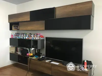 Modern living room with sleek wall-mounted entertainment unit and large flat-screen TV.