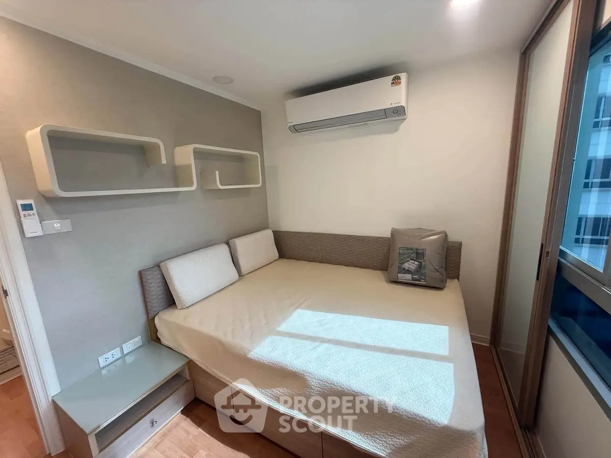 Cozy bedroom with modern air conditioning and stylish shelving in a bright apartment.