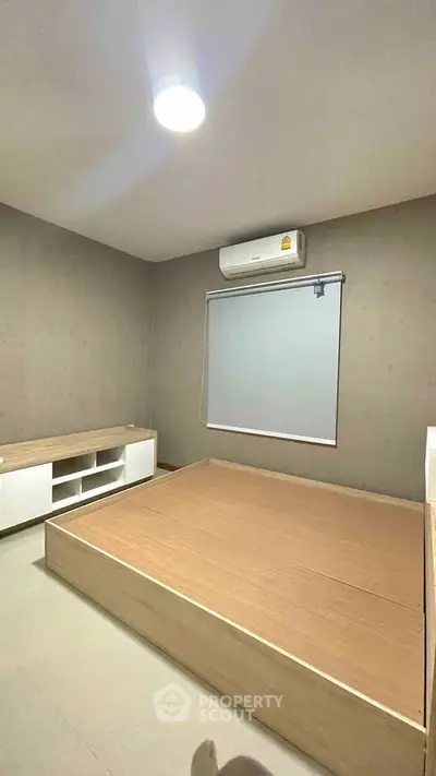 Modern minimalist bedroom with built-in wooden bed and air conditioning
