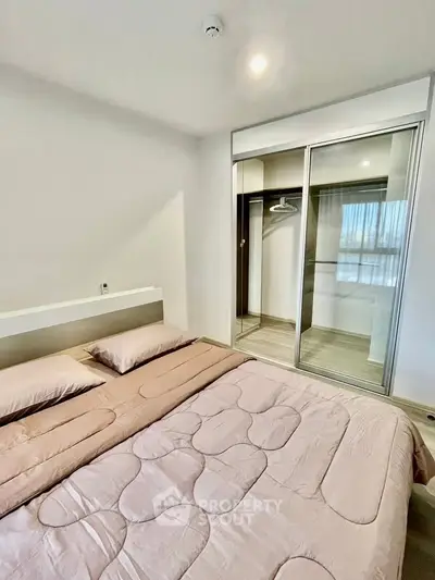 Modern bedroom with cozy bedding and built-in wardrobe in a stylish apartment.