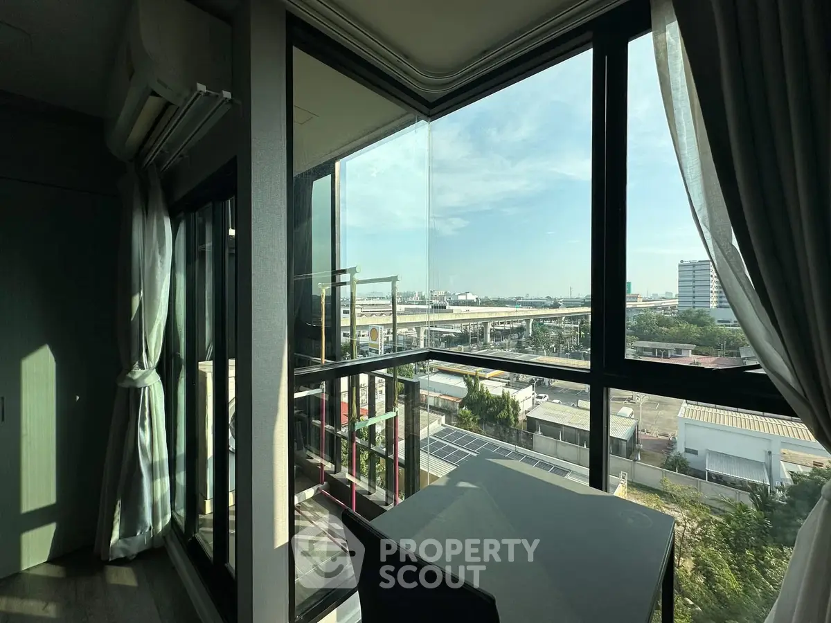 Modern apartment with large windows offering stunning cityscape views and abundant natural light.