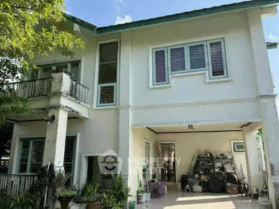 Charming two-story house with spacious garage and lush greenery, perfect for family living.