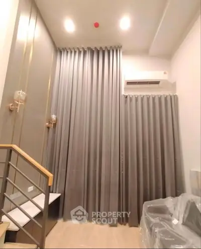 Modern high-ceiling living room with elegant curtains and stylish lighting